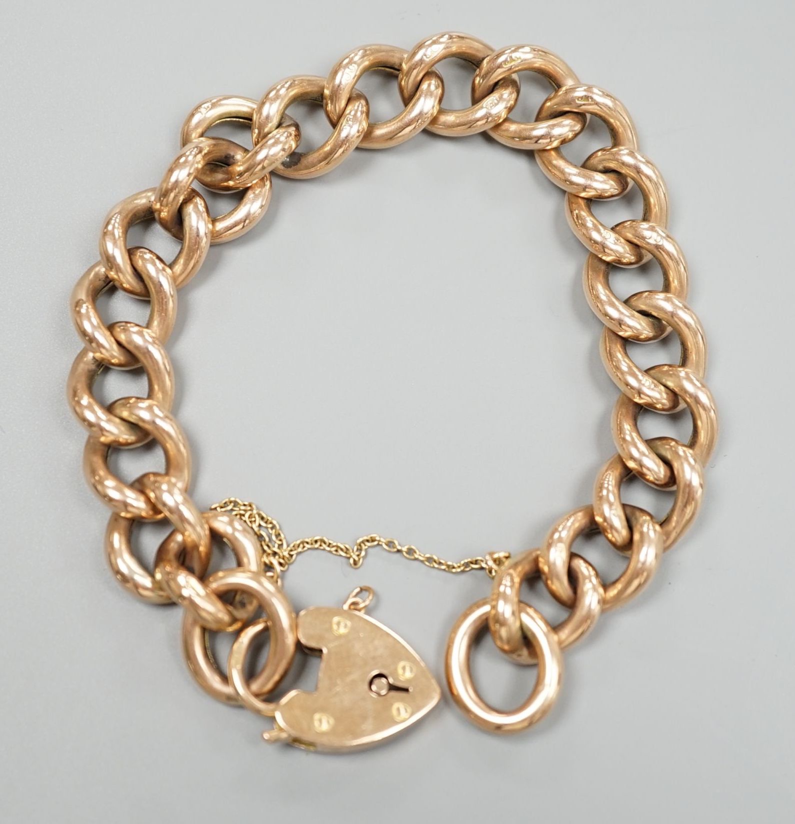 An Edwardian 9ct gold curblink bracelet, with heart shaped padlock clasp, approx. 19cm, 20.3 grams.